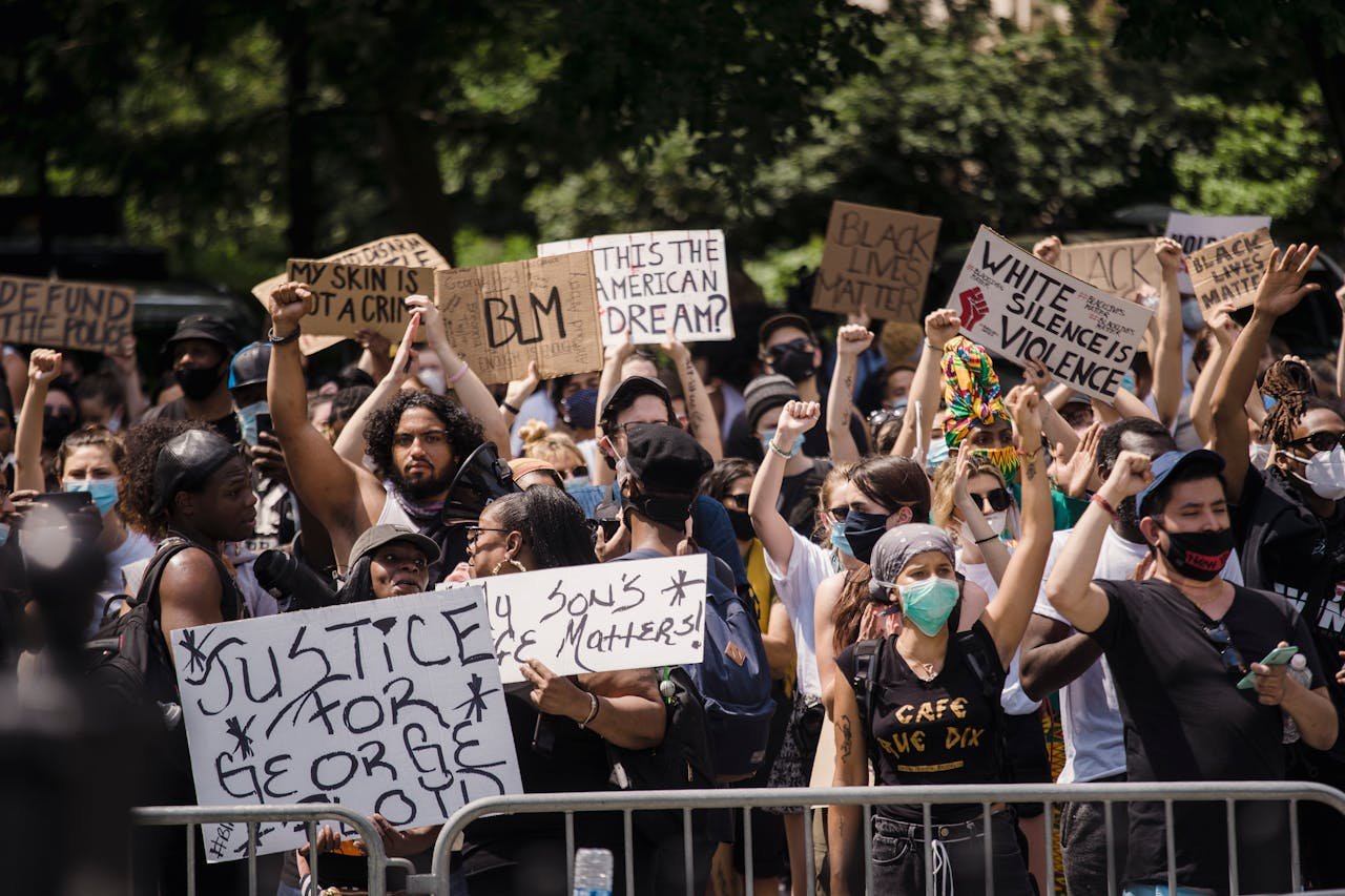 Protesters rally for justice and equality, displaying powerful signs in a city street.